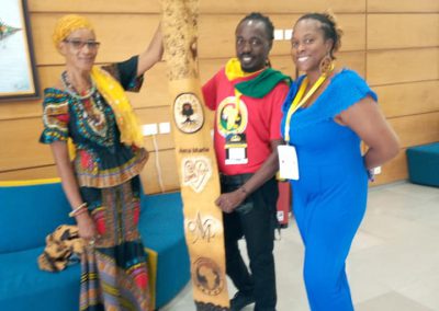 Three people holding a decorative wooden item.