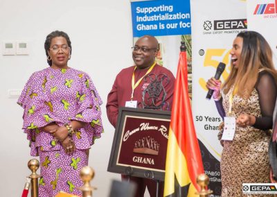 People at Ghana industrialization event with signs.