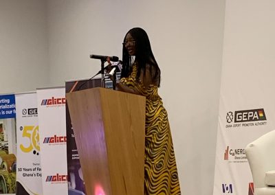 Woman speaking at podium during conference event.
