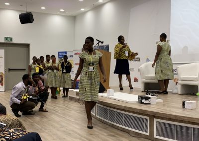 Women presenting at a conference on stage.