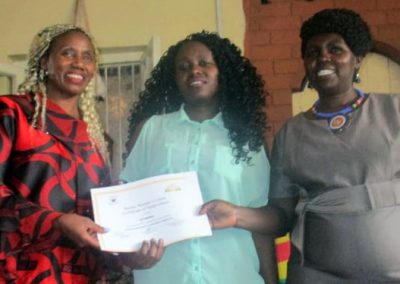 Three women holding a certificate, smiling.