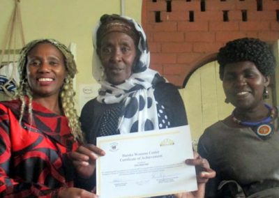 Three women holding a certificate, smiling.