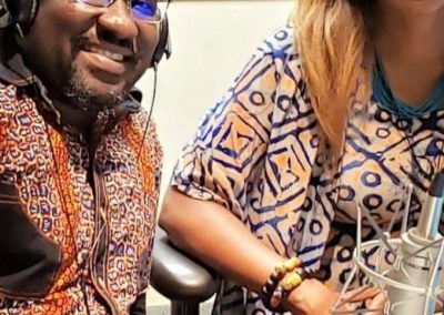 Two people smiling in a radio studio.
